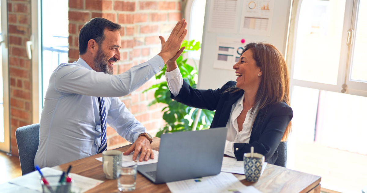 People high-fiving in office