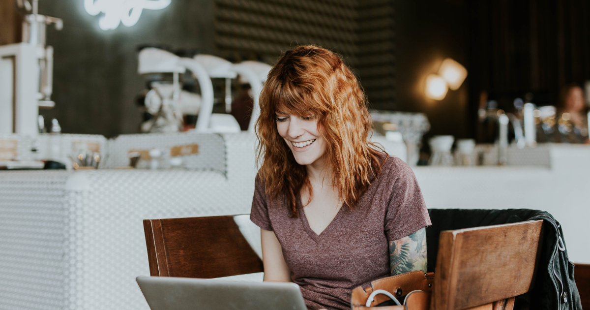 Tattoed woman looking at laptop